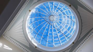 A circular skylight with a blue glass roof, surrounded by white decorative moldings.