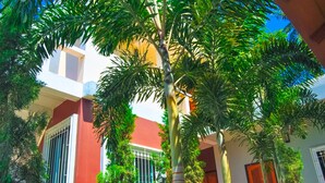 A building with a red facade, white window frames, and a door with a wooden door frame. - Sarin Guesthouse (Koh Tao)