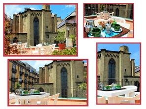 A courtyard with a dining table set for two, surrounded by white chairs, and a building with a large arched window and stone walls. - B&B La Storia di Napoli (Naples)