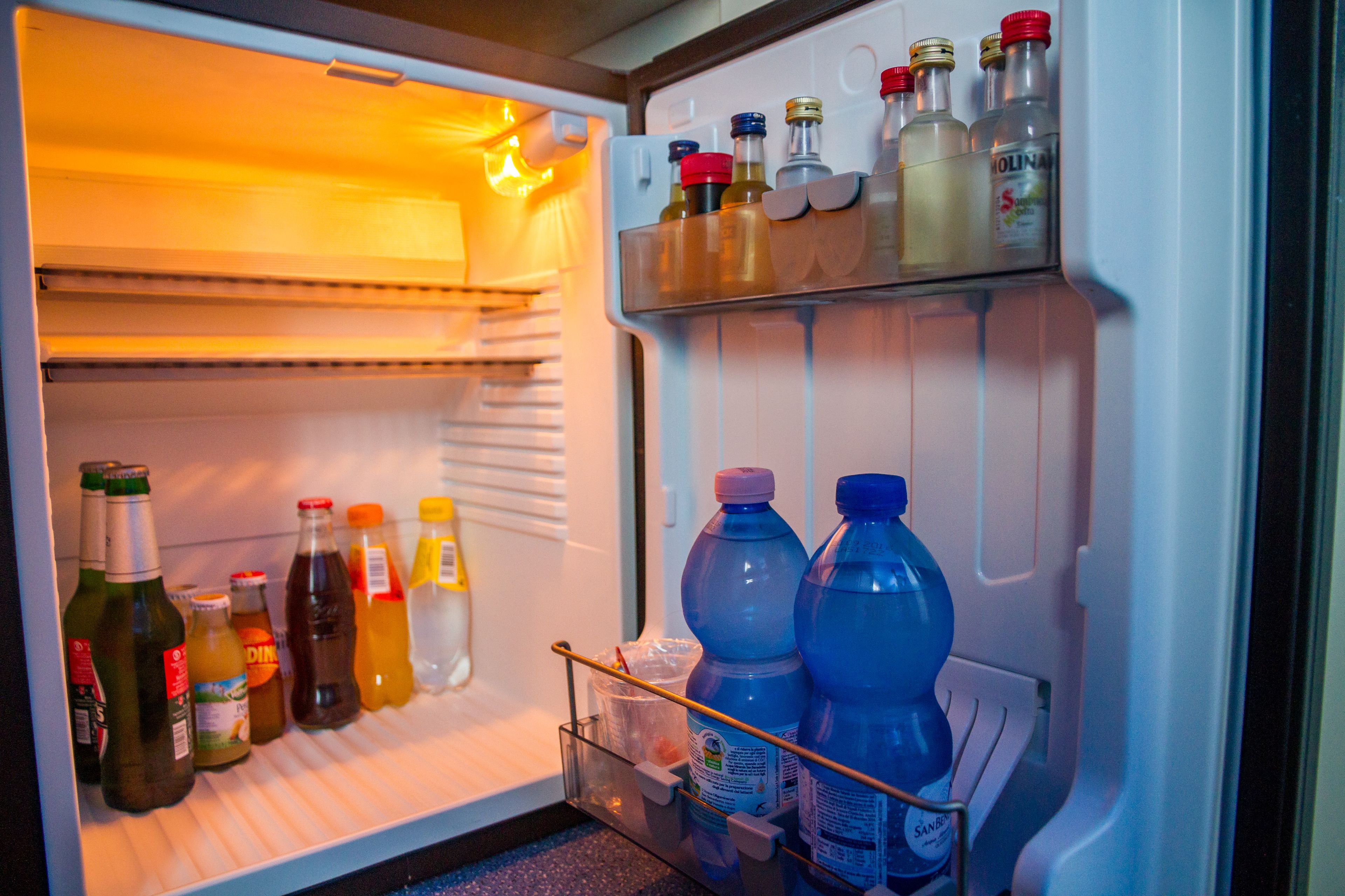 Un réfrigérateur ouvert, contenant diverses boissons et bouteilles.