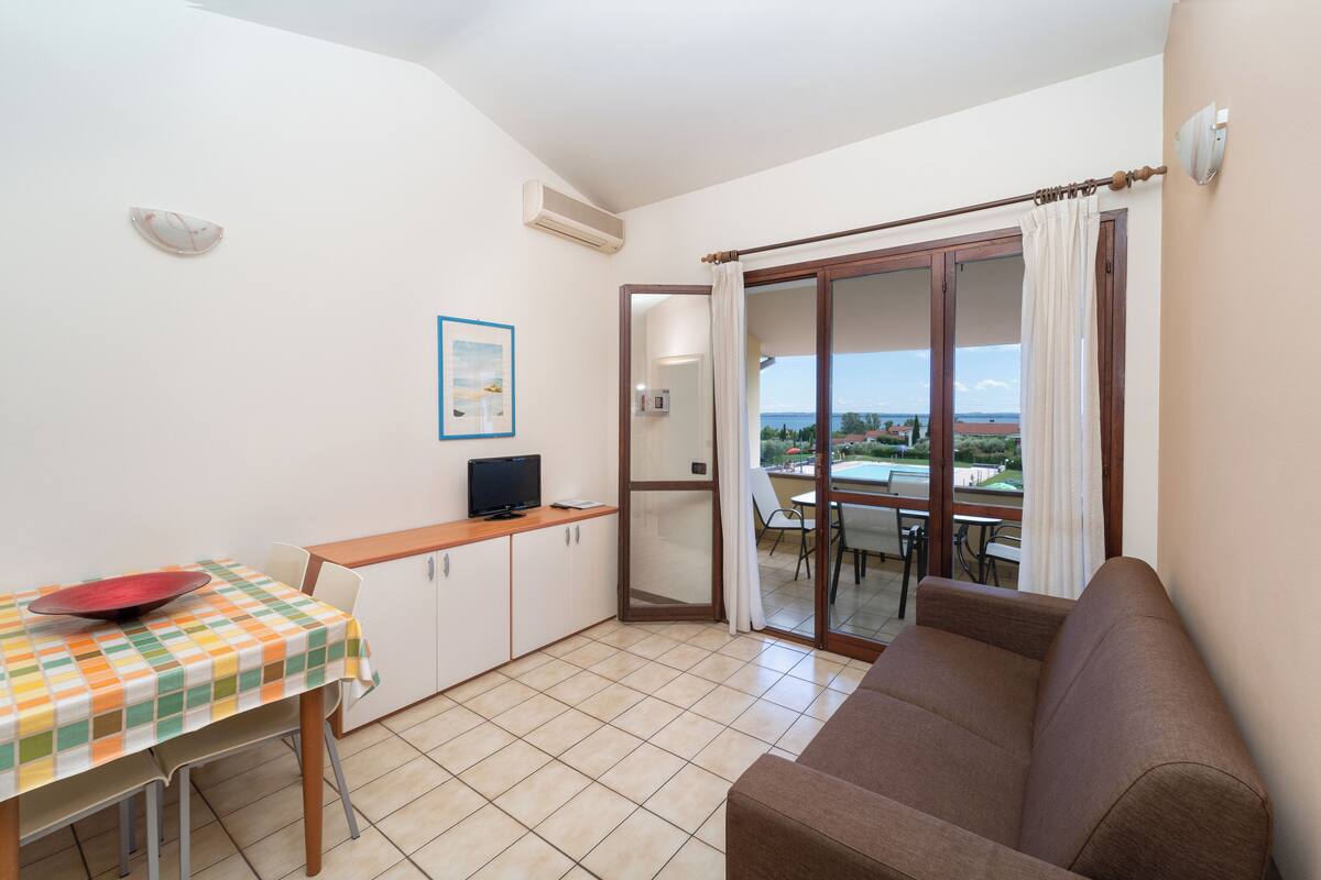A compact living space with a kitchenette, a dining area, and a sofa.