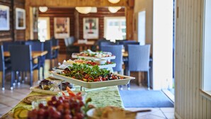 Een buffetopstelling met verschillende gerechten in een houten ambiance.