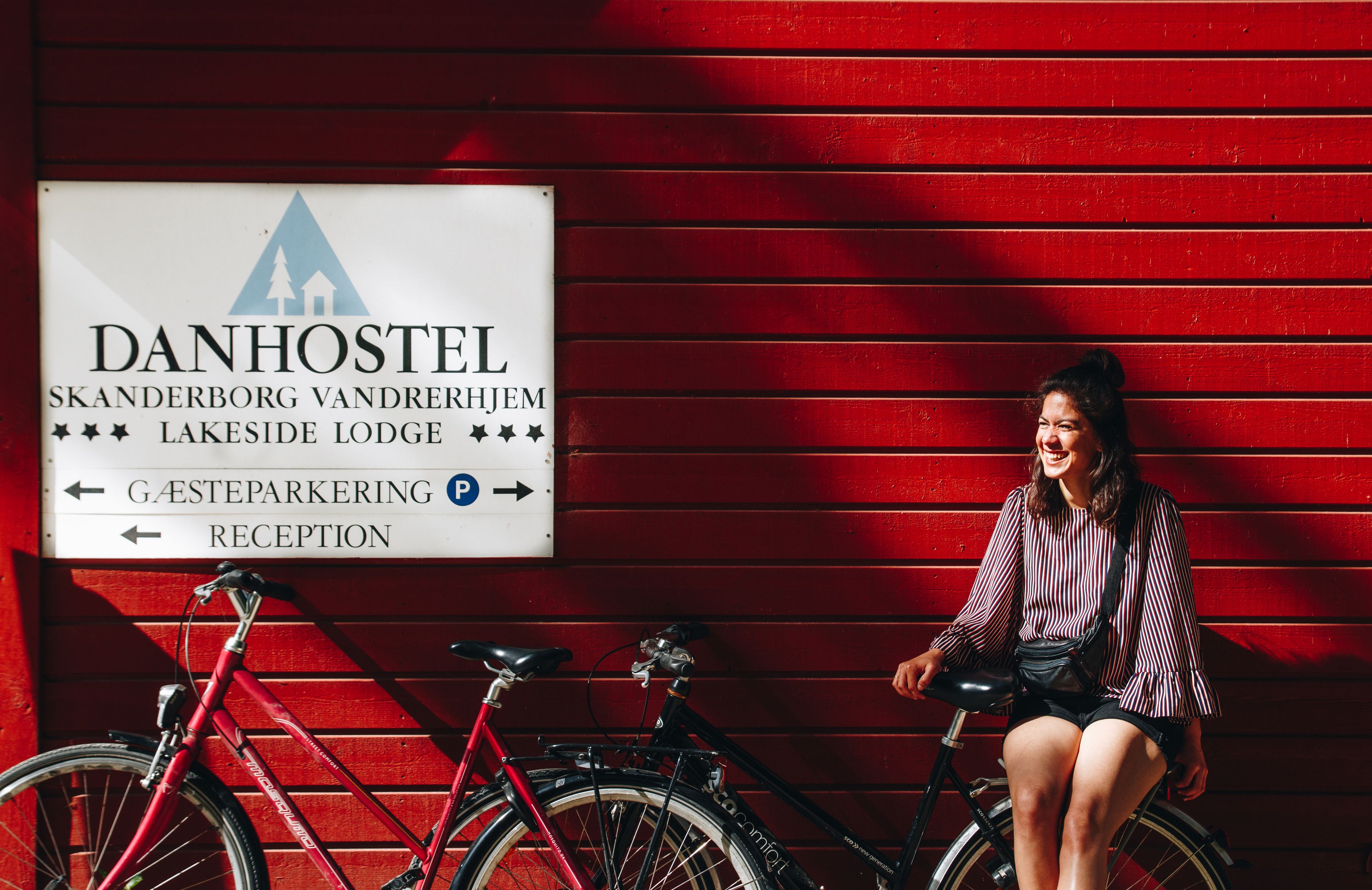 Un cartel de DanHostel con indicaciones hacia Gasteparkering y Recepción.