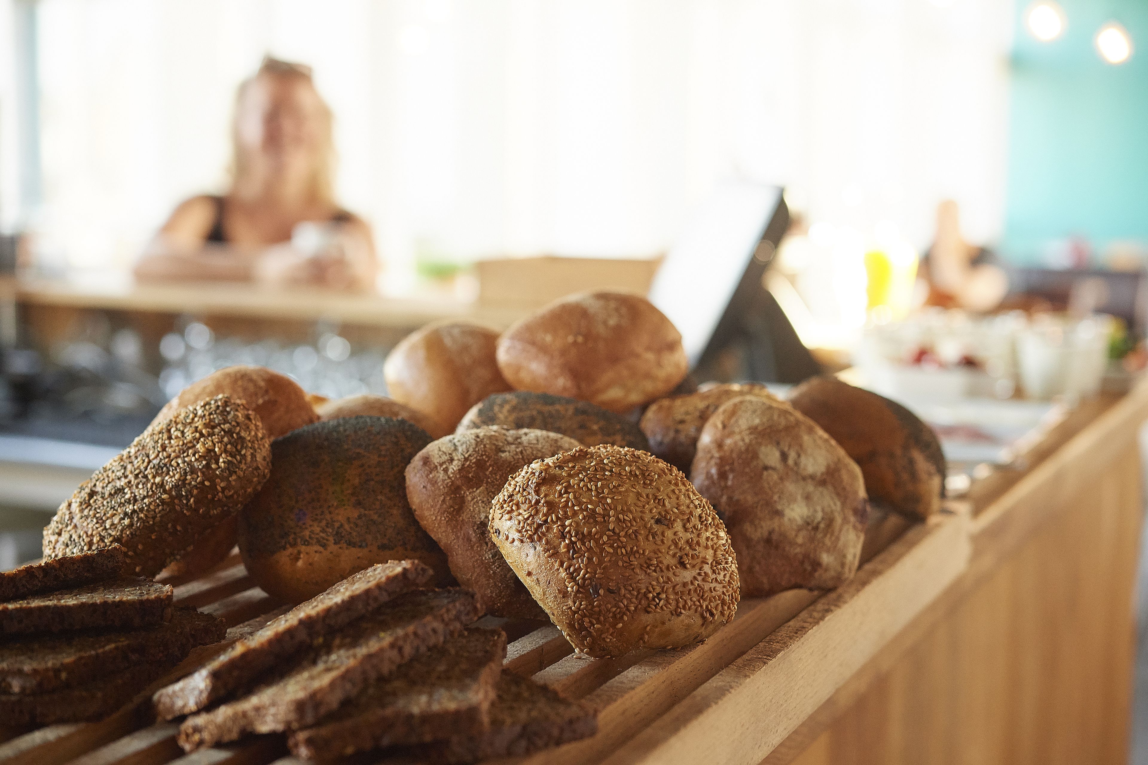 A variety of breads displayed on a wooden counter.