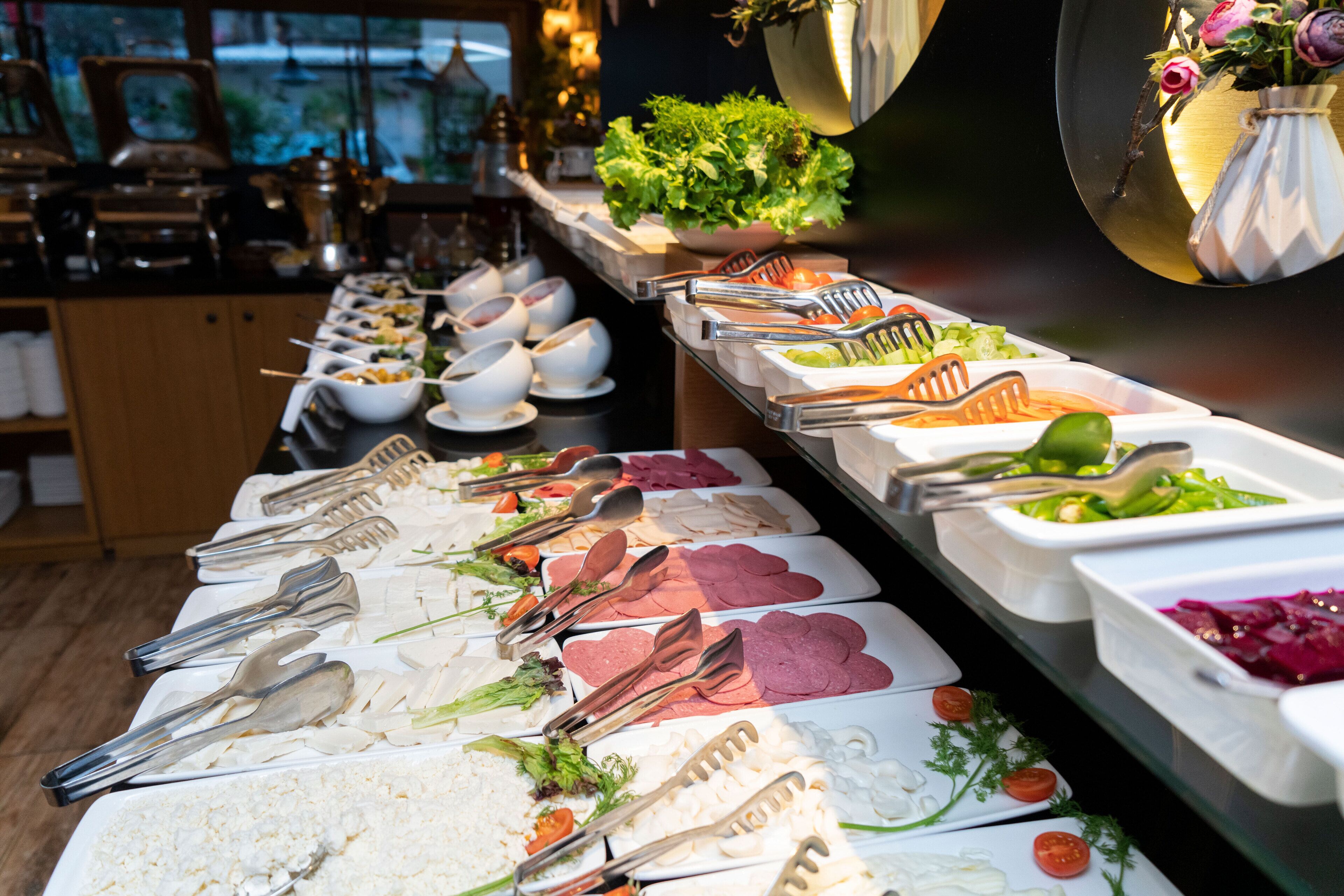 A buffet with various food items and utensils.