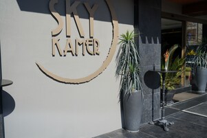 Señal de hotel con el nombre "SKY Namer" y un elemento decorativo circular.