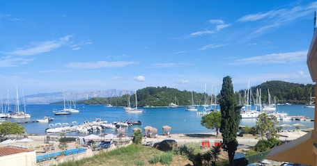 A marina with boats docked, a swimming pool, and a view of a mountainous landscape.