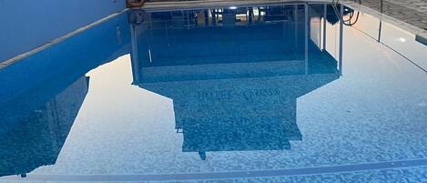 A hotel named 'HOTEL - Oscar' with a pool area and outdoor seating.
