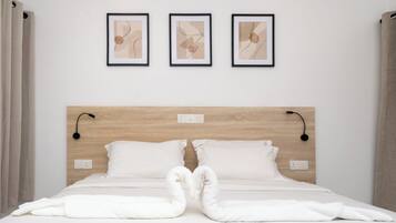 Deluxe Quadruple Room, Garden View | Minibar, in-room safe, desk, laptop workspace
