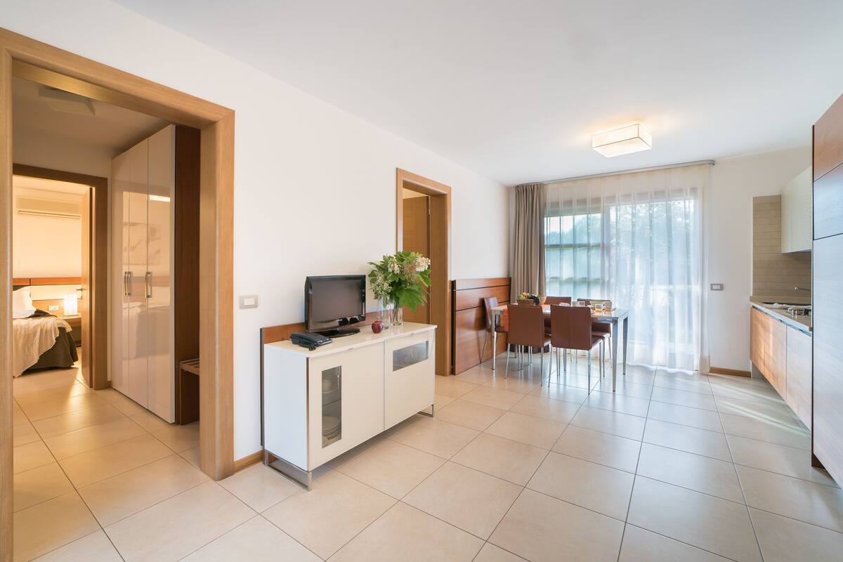 Une chambre d’hôtel moderne dotée d’une kitchenette, d’un coin repas et d’une chambre à coucher séparée.