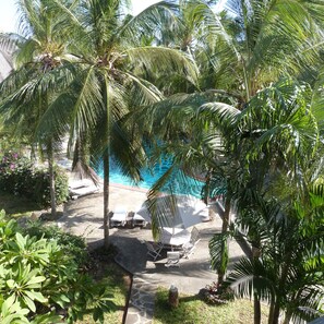 A pool area with lounge chairs and palm trees. - Aquarius Club International Resort (Watamu)