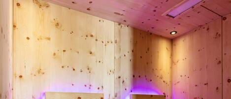 A wooden cabin with two wooden beds and a ceiling light.