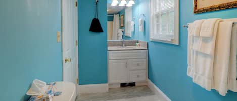 Une salle de bain avec des toilettes, un lavabo et un miroir.