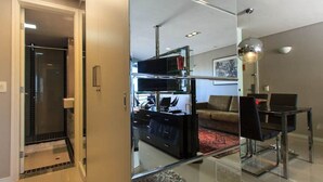 A modern living room with a glass partition, a sofa, a coffee table, and a TV. - Flat Iate (Fortaleza)