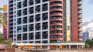A high-rise hotel with multiple balconies, a beachside location, and a pool area. - Flat Iate (Fortaleza)