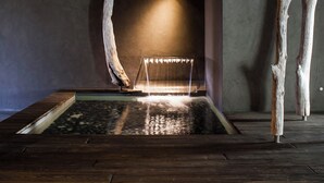 A wooden floor with a water feature and a light source in the background.