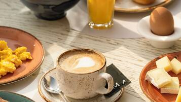Una tavola imbandita per la colazione con diversi cibi e una tazza di caffè.