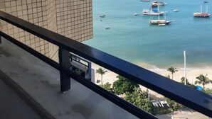 A view from a balcony overlooking a beach with boats in the water and a distant ship. - Flat Golden Fortaleza (Fortaleza)