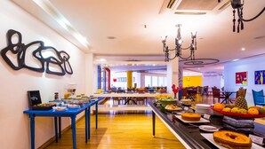 A buffet setup with various food items and a blue table. - Flat Golden Fortaleza (Fortaleza)