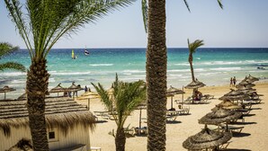 A beach with thatched umbrellas and palm trees. - ROBINSON DJERBA BAHIYA - All inclusive (Aghir)