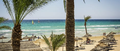 På stranden, parasoller, strandhanddukar och volleyboll