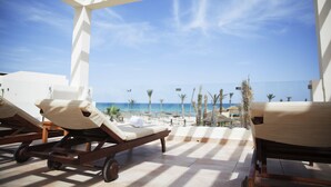 A sunlit outdoor lounge area with two wooden lounge chairs and a white pergola structure. - ROBINSON DJERBA BAHIYA - All inclusive (Aghir)