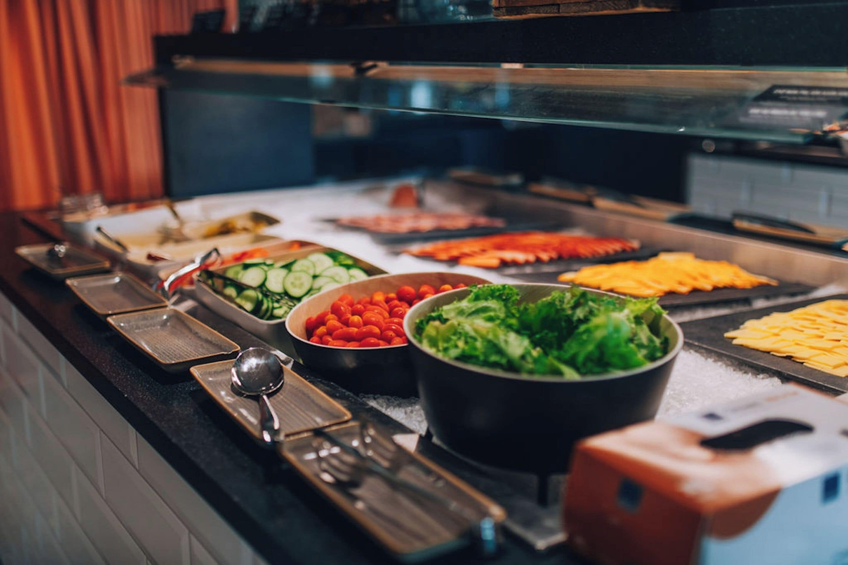 A buffet with various food items including vegetables, salads, and meats.