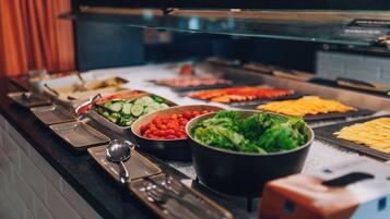 A buffet with various food items including vegetables, salads, and meats.