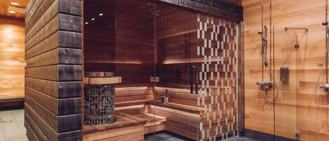 A sauna with wooden benches and a glass partition.