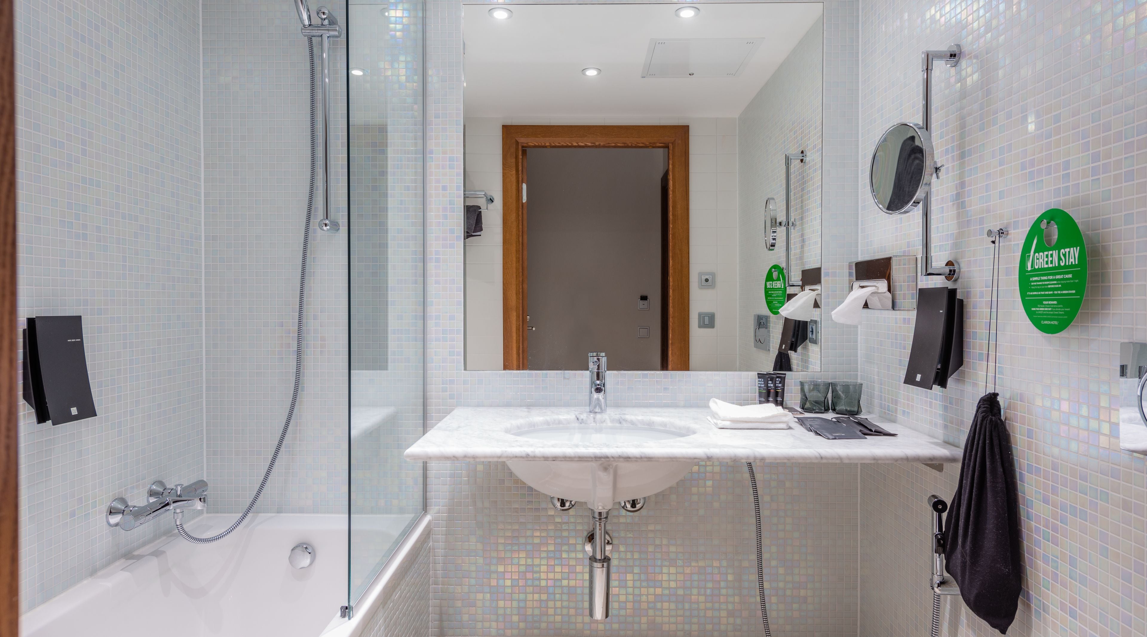 Une salle de bain moderne avec une douche à parois de verre, un lavabo avec un miroir et un porte-serviettes.