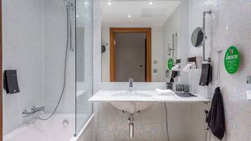 Une salle de bain moderne avec une douche à parois de verre, un lavabo avec un miroir et un porte-serviettes.