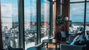 A modern interior with large windows, a city view, and contemporary furniture. - Clarion Hotel Helsinki (Helsinki)