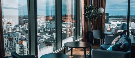 A modern interior with large windows, a city view, and contemporary furniture.