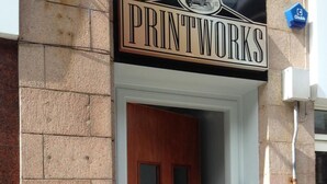 A building entrance with a sign reading "PRINTWORKS" above a wooden door. - Printworks Apart-Hotel (Peterhead)