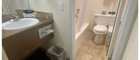 Une salle de bain comprenant un lavabo, des toilettes et un espace douche.