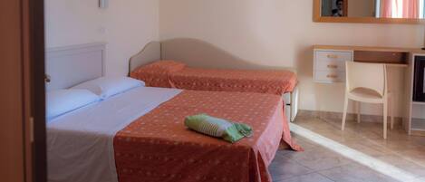 A bedroom with two beds, a desk, and a chair.