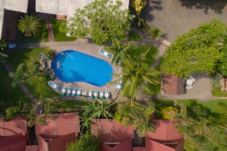 Una piscina al aire libre, sillones reclinables de piscina
