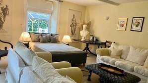 A room with a bed, two sofas, a table with a lamp, and a bust sculpture. - Grange Farm House (Thetford)