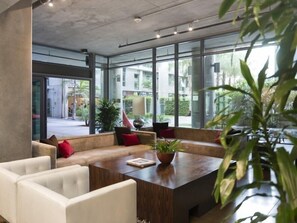 A modern interior with a large glass wall, a wooden table, and seating areas. - Tripbz Mello Lofts (Los Angeles)