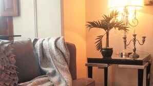 A living room with a sofa, a lamp, and a potted plant on a side table. - Casa Monraz (Guadalajara)