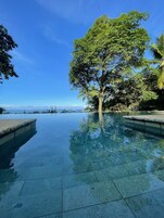 Una piscina al aire libre, sillones reclinables de piscina