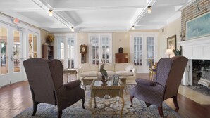 Un salon spacieux doté d’une cheminée, d’une grande fenêtre et d’un coin salon confortable.
