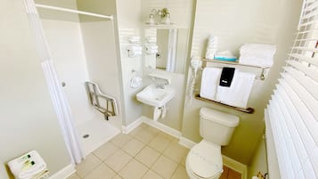 Ein Badezimmer mit Dusche, Toilette, Waschbecken und Handtuchhalter.