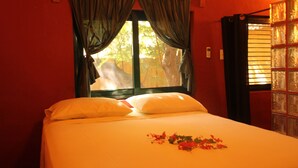 A bed with white linens and a floral arrangement on the bedspread.