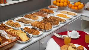 A buffet table with various pastries, bread, and fruits. - Hôtel Suisse (Algiers)