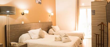 Habitación de hotel con dos camas, una mesita de noche con lámpara, aire acondicionado instalado en la pared y un armario de madera.