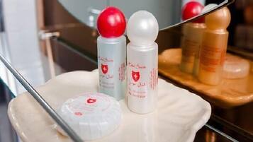 A tray with two bottles of liquid and a container with a red cap, placed on a reflective surface.
