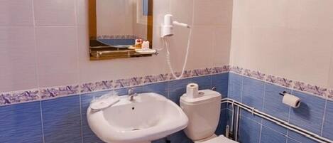 A bathroom with a sink, toilet, and shower.