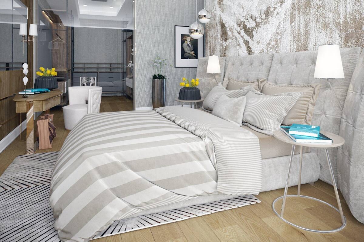 Un dormitorio moderno con una cama grande, mesitas de noche, un espejo y vistas al baño contiguo.