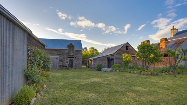 A rural property with a grassy yard, wooden barns, and a corrugated metal building. - White's Corner (Bothwell)
